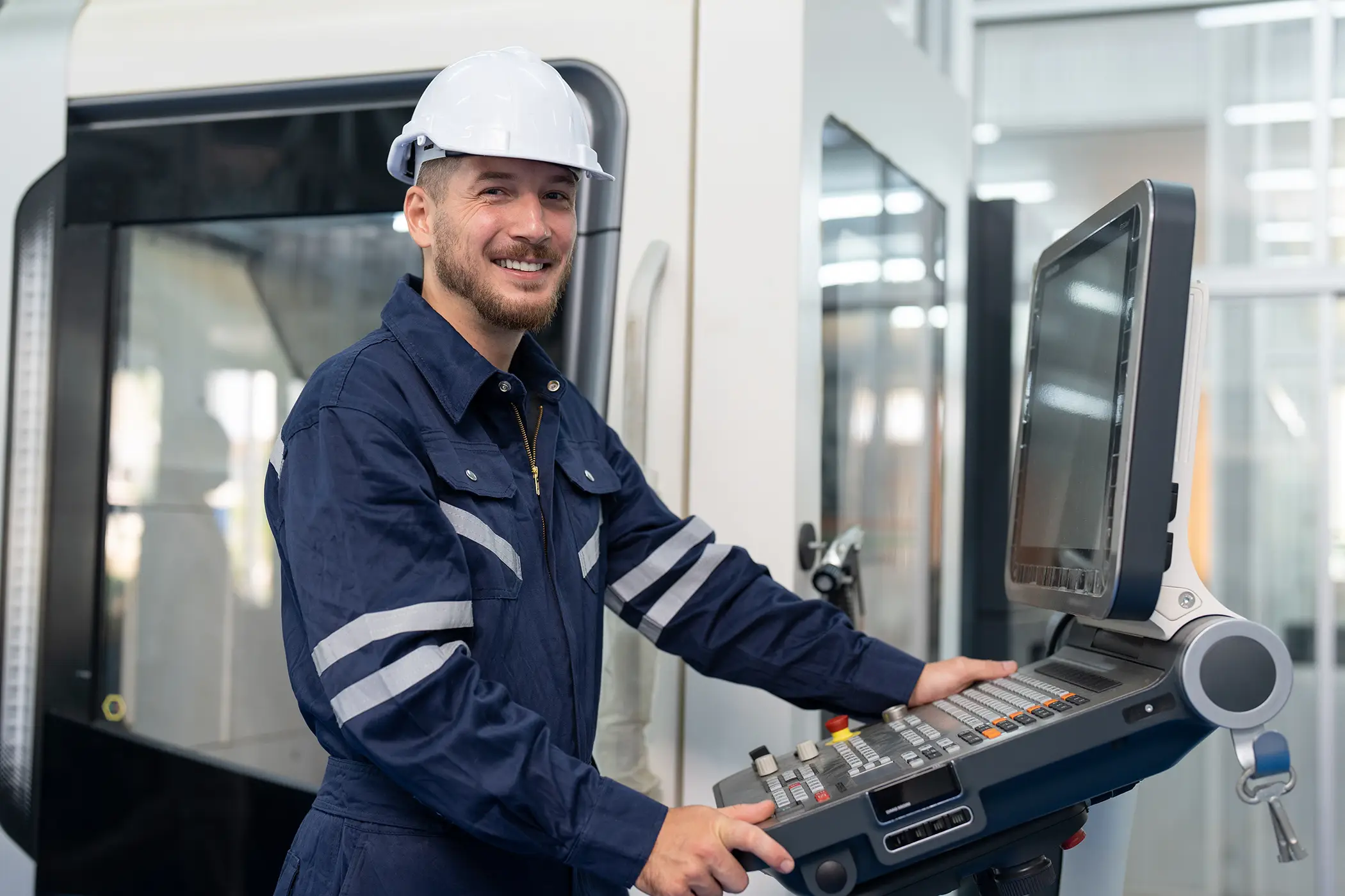 Male engineer operating cnc machine in control panel at factory